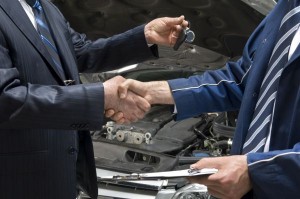 Mechanic motor trader exchanging car keys